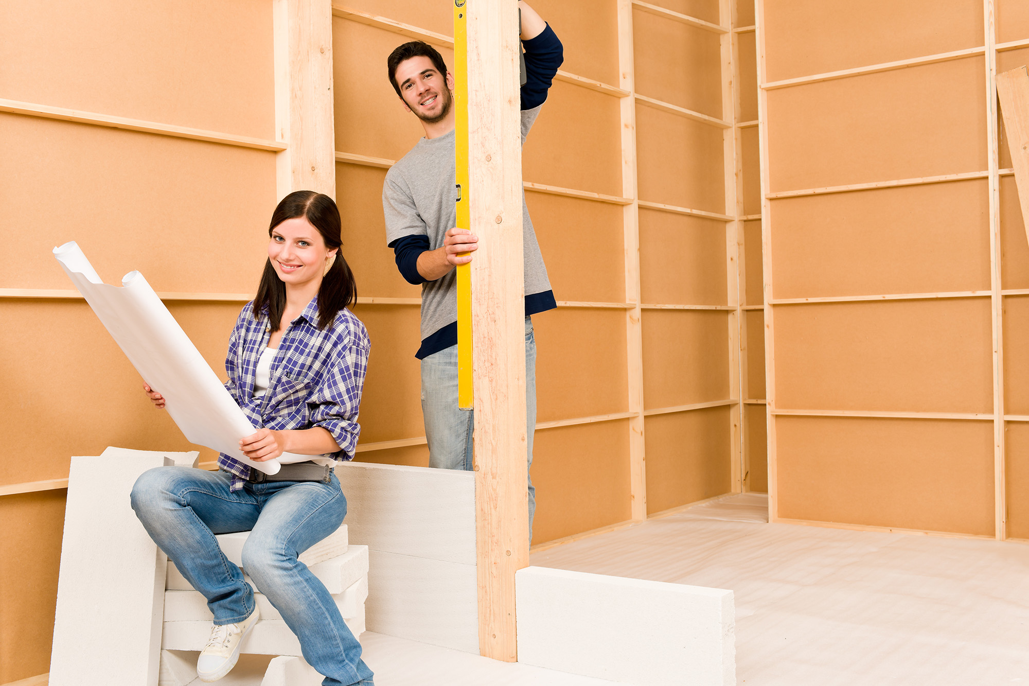 Home improvement happy young couple with architectural blueprints fixing house